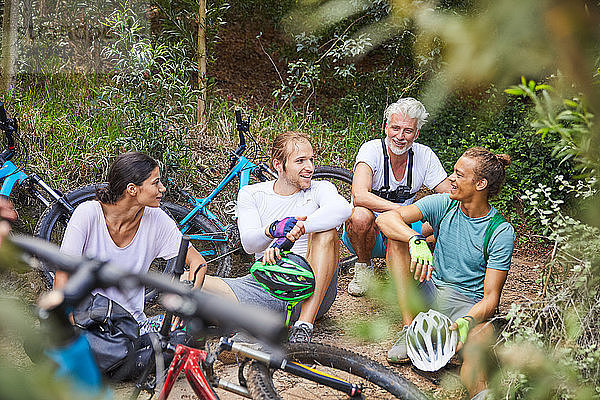 Friends mountain biking  resting in woods