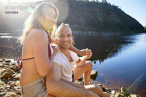 Portrait affectionate  carefree couple holding hands at sunny summer lake