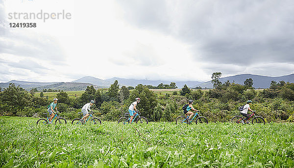 Friends mountain biking in idyllic  remote field