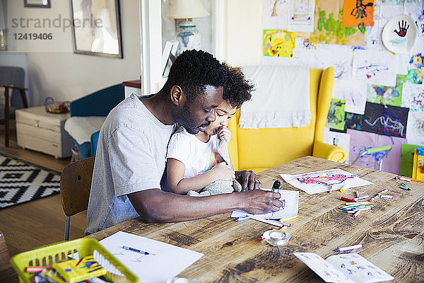 Vater und Kleinkind Tochter Färbung am Tisch