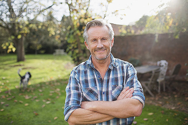 Porträt zuversichtlich älterer Mann in sonnigen Herbst Hinterhof