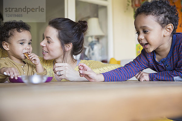 Mutter beobachtet ihren kleinen Sohn beim Essen am Tisch