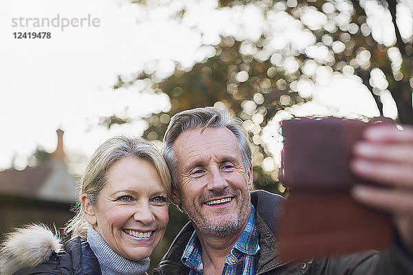 Lächelndes  glückliches reifes Paar  das ein Selfie mit einem Fotohandy macht