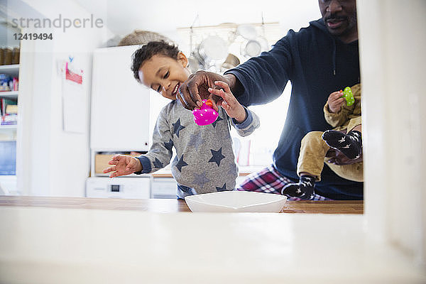 Vater und Kinder spielen in der Küche