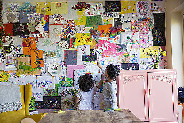 Kleinkind Bruder und Schwester hängen Kunst an der Wand