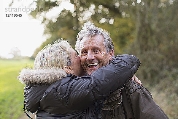 Porträt glückliches  verspieltes reifes Paar  das sich im Park umarmt