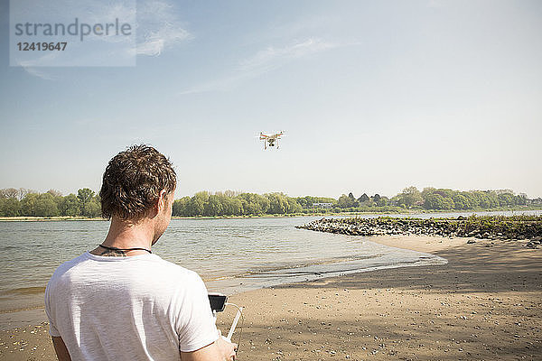 Man flying drone at a river