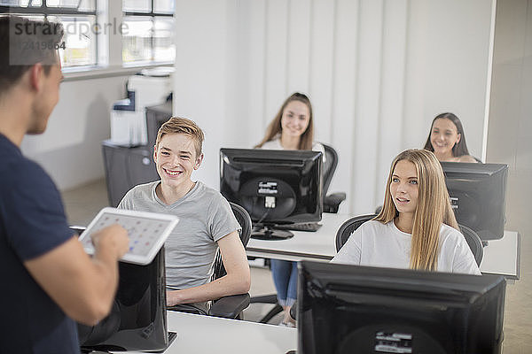 Teacher talking to students in computer class