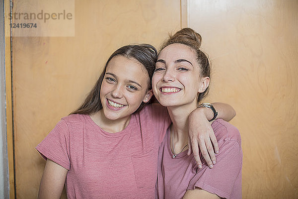 Portrait of two smiling teenage girls hugging