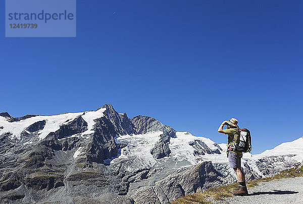 Austria  Carinthia  man  hiker with binoculars watching Grossglockner peak  High Tauern National Park
