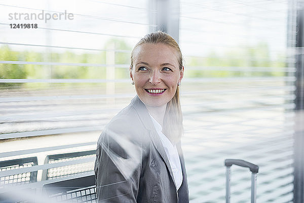 Portrait of smiling mature businesswoman waiting at platform