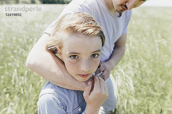 Portrait of boy and young man in a field