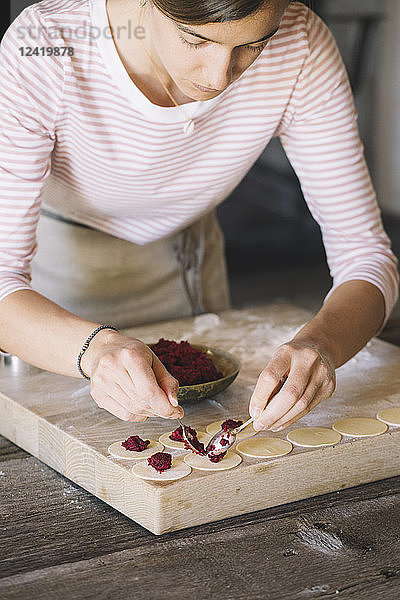 Woman preparing ravioli  beetroot sage filling
