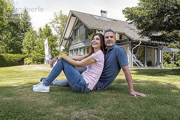 Happy couple sitting in garden of their home