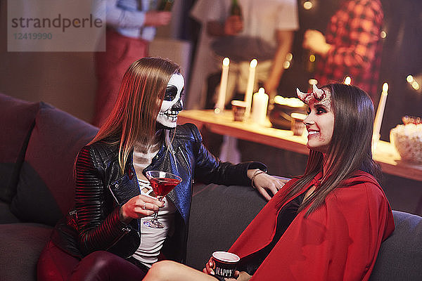 Women in creepy costume drinking at party