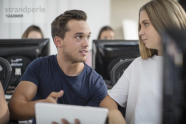 Teacher talking to student in computer class