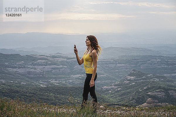 Spain  Barcelona  young woman taking selfie on Montcau Mountain