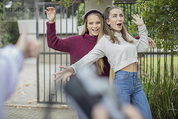 Teenage girl taking a picture of her happy friends outdoors