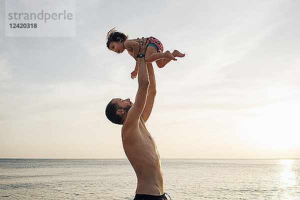 Thailand  Koh Lanta  father playing with his little daughter on the beach at sunset