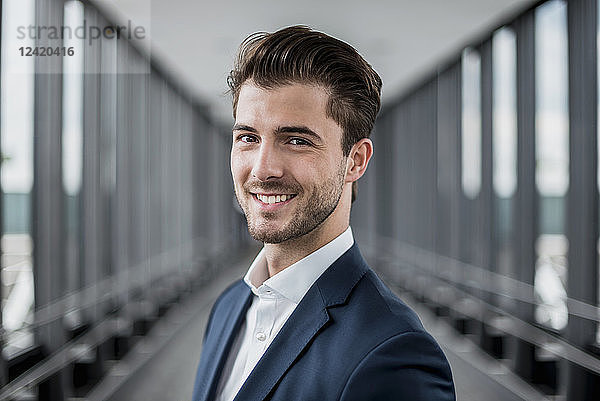 Portrait of smiling young businessman in a passageway