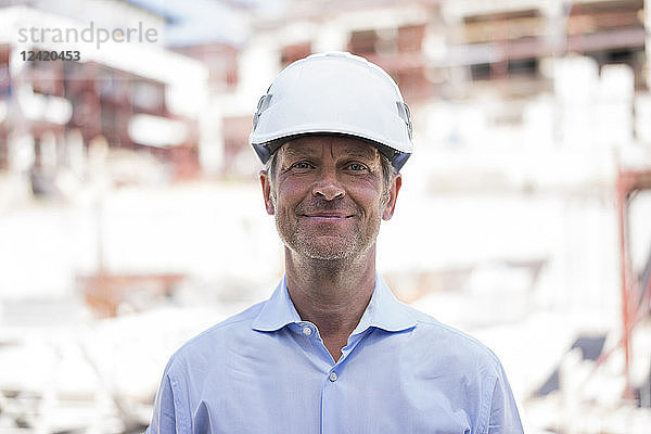 Portrait of confident man wearing hard hat on construction site