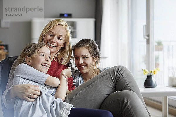 Happy mother and daughters having fun at home