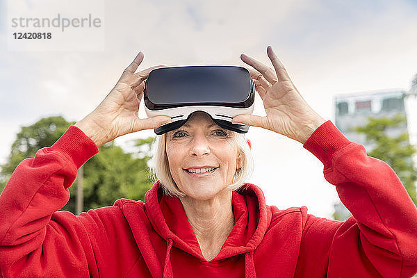 Portrait of smiling senior woman wearing VR glasses