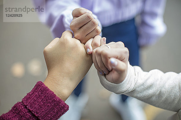 Close-up of teenage girls making a pinky promise