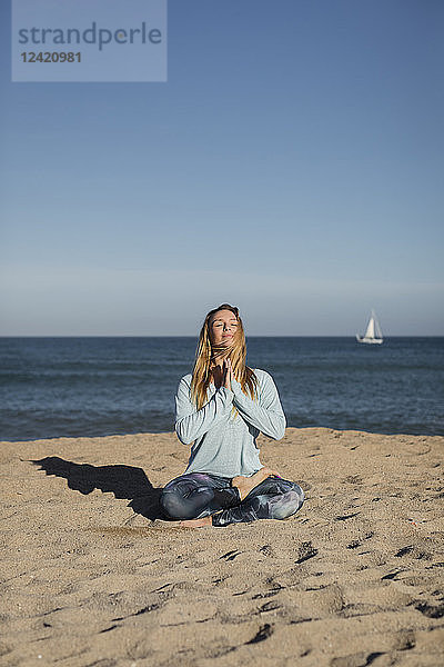 Woman doing yoga on the beach  lotus position