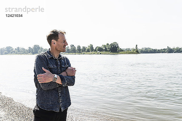 Thoughtful mature man at Rhine riverbank