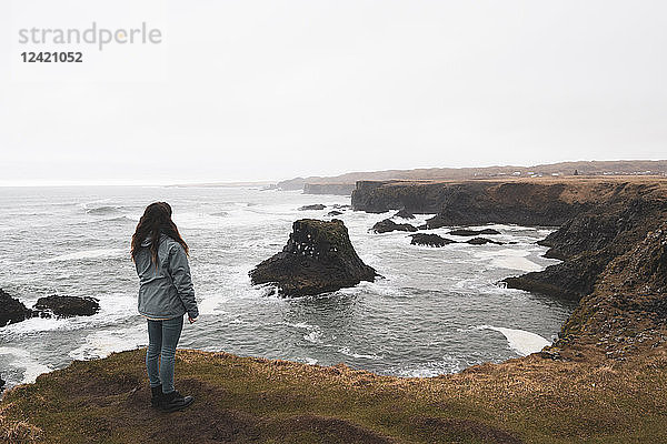 Iceland  back view of woman standing at coast