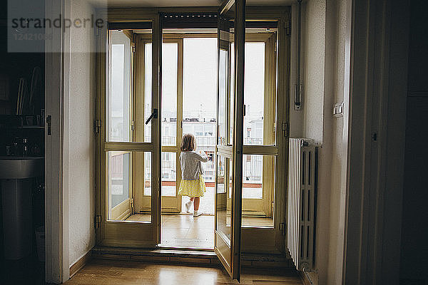 Italy  Naples  back view of little girl standing at door of roof terrace