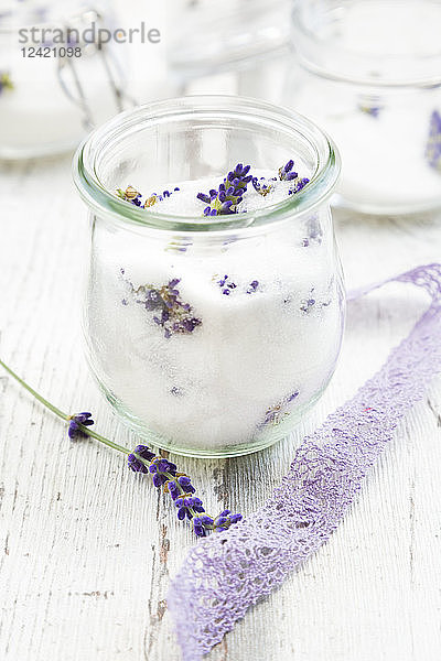 Glass of homemade lavender sugar with lavender blossoms