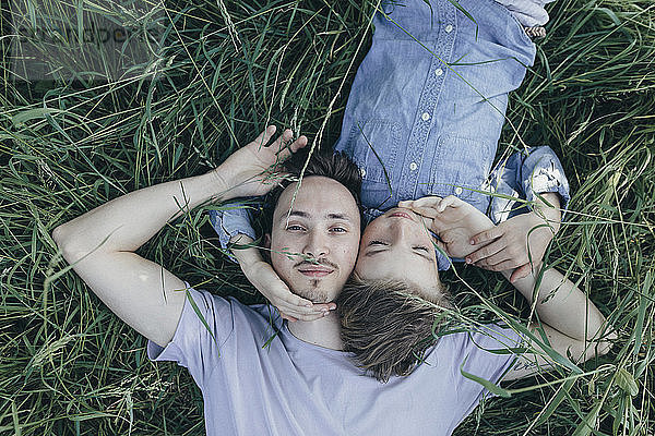 Young man and boy lying in field