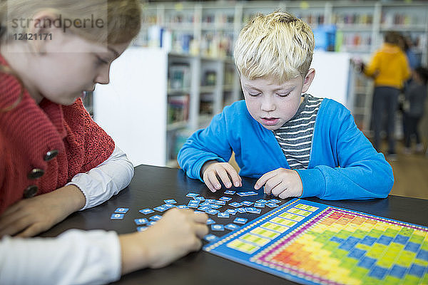 Pupils playing a board game in school library