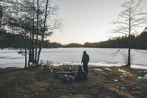 Sweden  Sodermanland  backpacker resting at a remote lake in winter