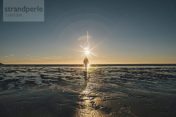 Norway  Lofoten  Moskenesoy  Man walking into the sunset at Kvalvika Beach