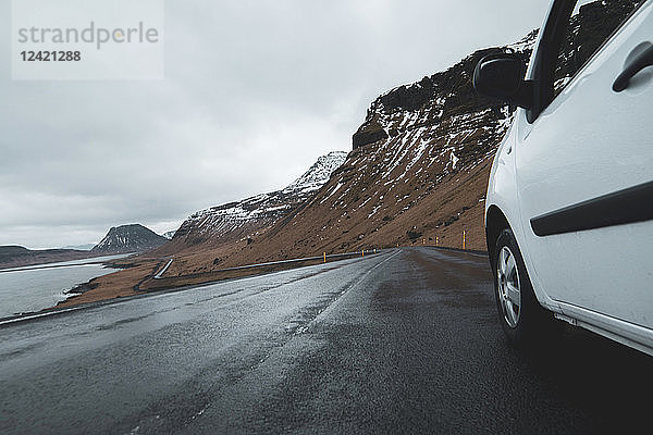Iceland  white car on wet coastal road