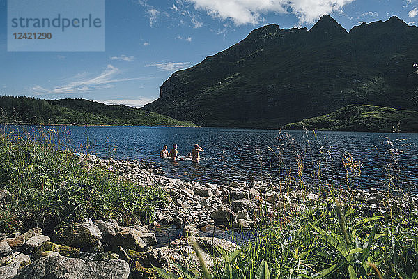 Norway  Lofoten  Moskenesoy  Three men bathing in Lake Agvatnet