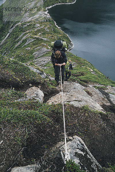 Norway  Lofoten  Moskenesoy  Group of young men hiking at Vinstad