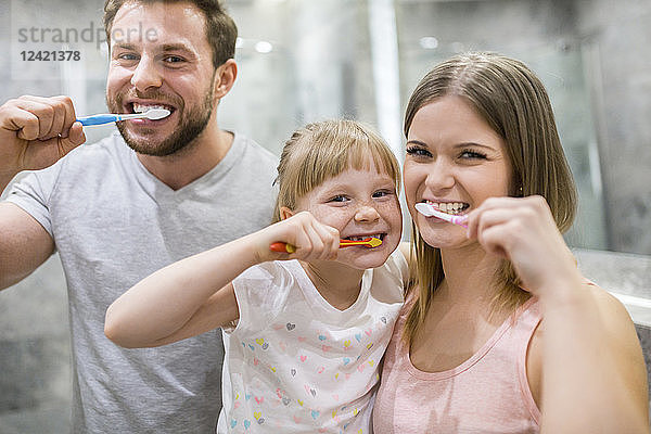Happy family brushing teeth together
