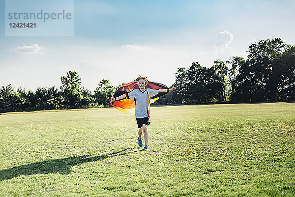 Boy  enthusiastic for soccer world championship  waving German flag