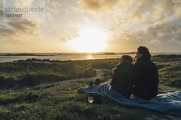 France  Brittany  Landeda  couple sitting at the coast at sunset