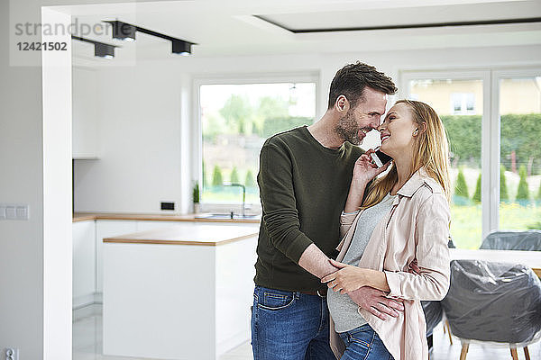 Man kissing pregnant woman in empty flat
