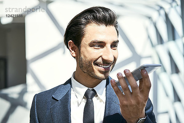 Smiling businessman using smartphone