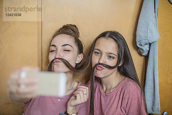 Playful happy teenage girls taking a selfie