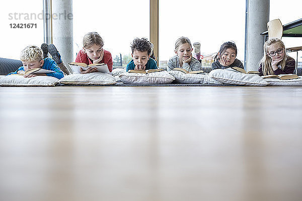 Pupils lying on the floor reading books in school break room
