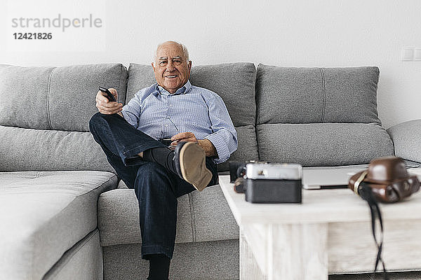 Senior man watching TV from the couch at home