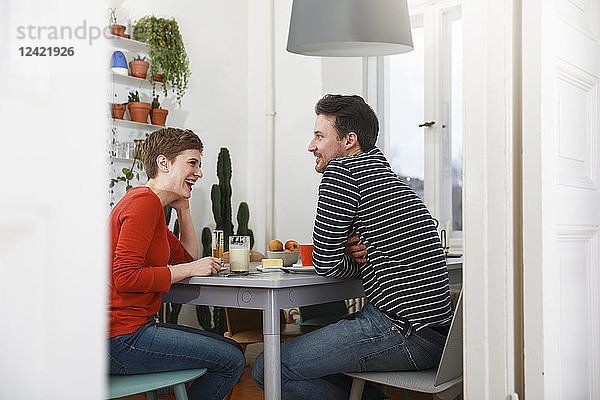 Couple sitting in kichen  talking  having breakfast
