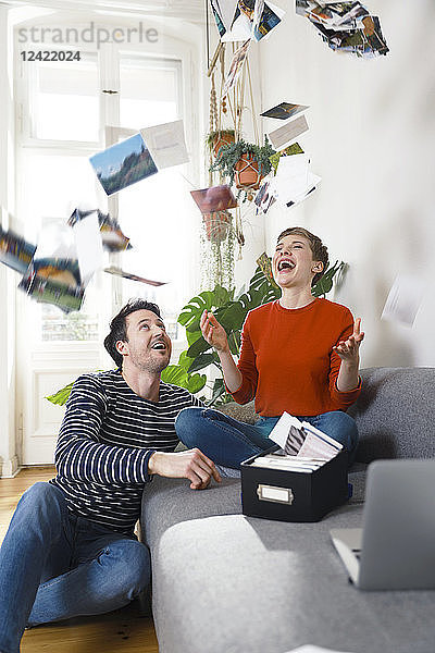 Couple sitting at home   looking at old photographs